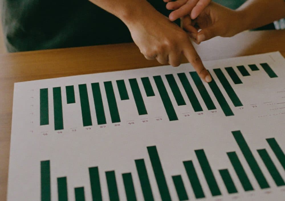 Two people reviewing a printed data report together, pointing at a chart, representing our transparent, evidence-based vetting process
